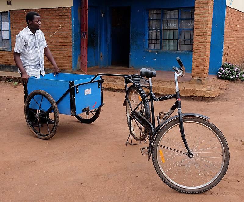 An African affixing a cart to his "Buffalo" bicycle